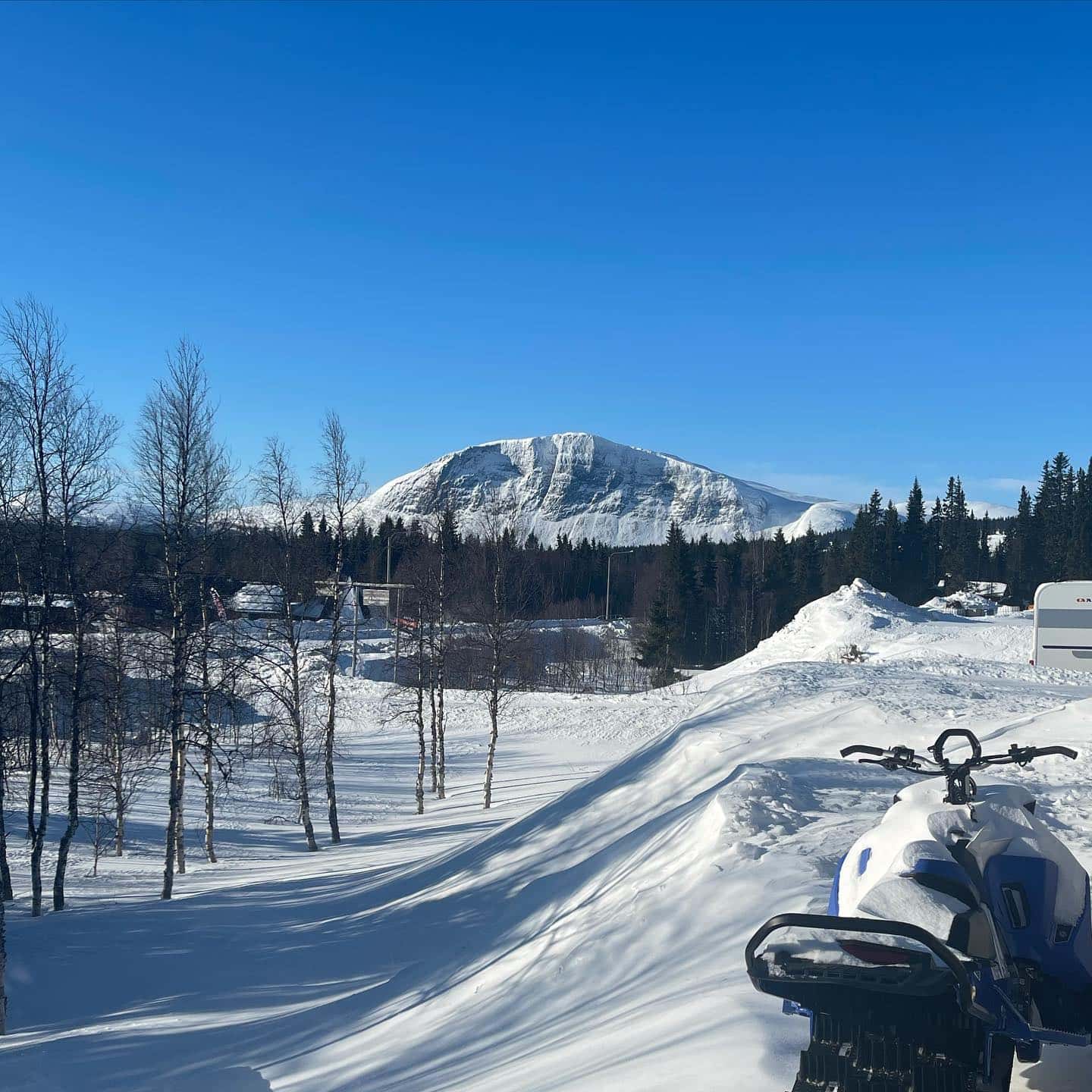 Snötäckt camping med fjället i bakgrunden